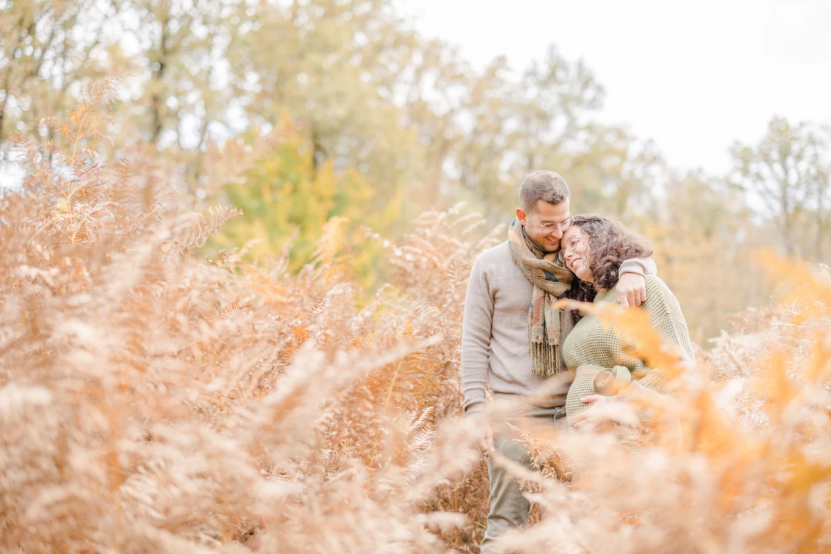 Père et fils enlacés dans un champ de fougères dorées en automne, moment de tendresse familiale