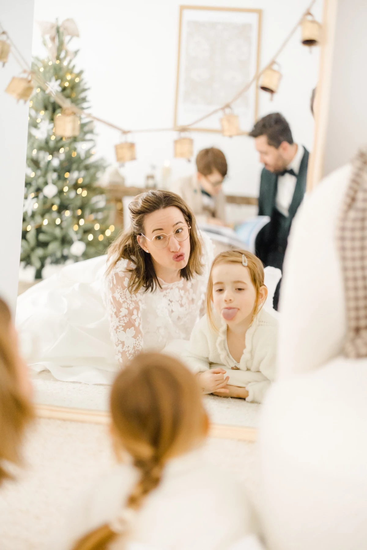 Mère et fille partageant un moment complice autour d'une table de Noël décorée dans des tons blancs