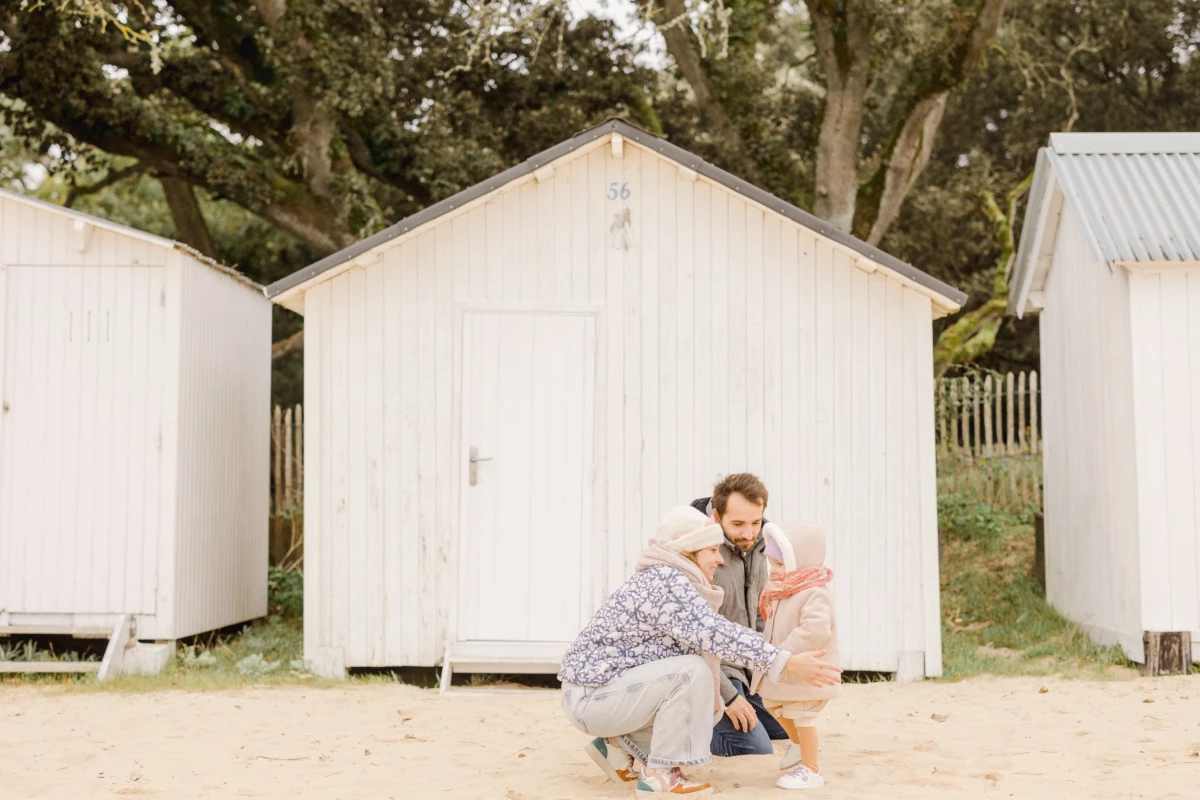 Mère et sa fille devant des cabines de plage blanches, moment de complicité au bord de la mer