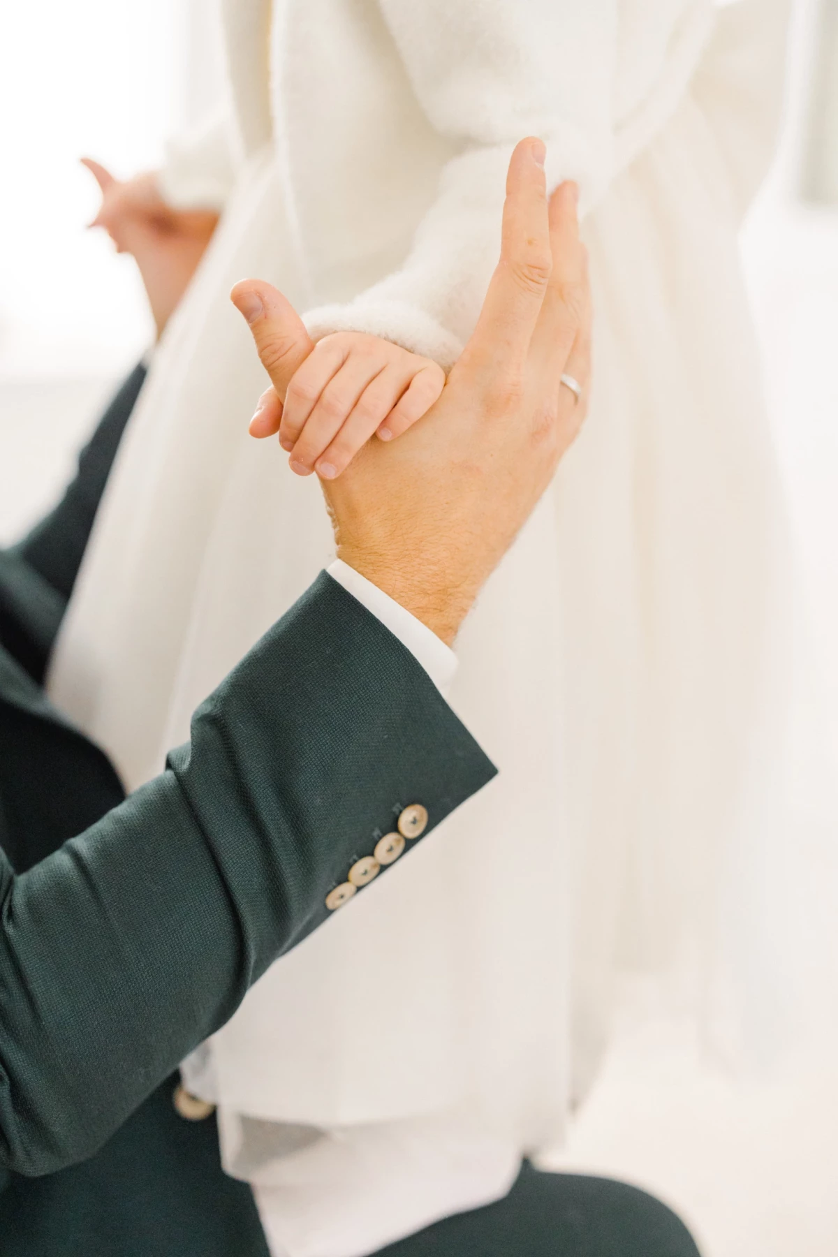 Mains d'un marié en costume ajustant sa manchette lors des préparatifs du mariage