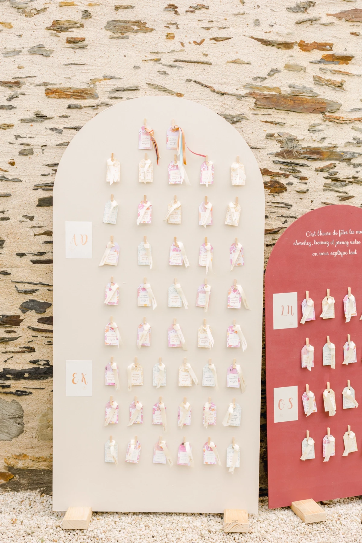 Plan de table minimaliste pour mariage avec étiquettes suspendues sur panneau arqué blanc